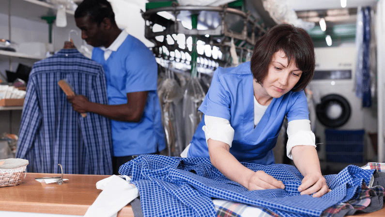 Portrait of skilled female laundry worker examining clean garments