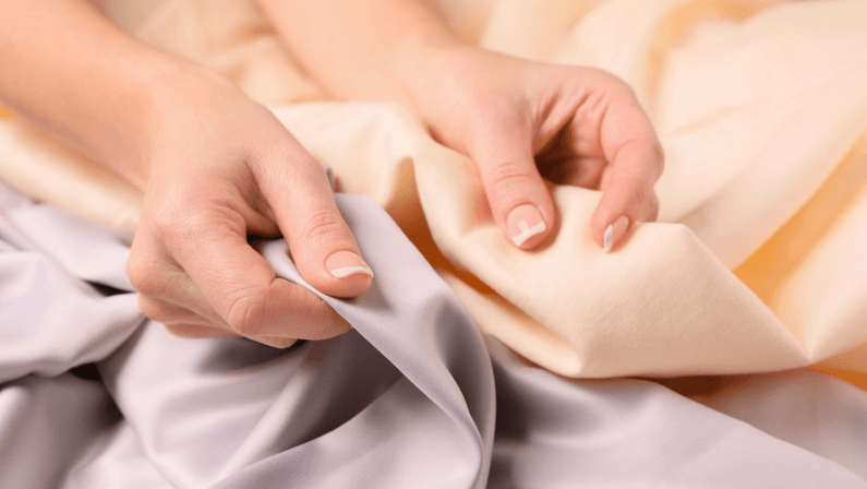 Woman touching different soft fabrics